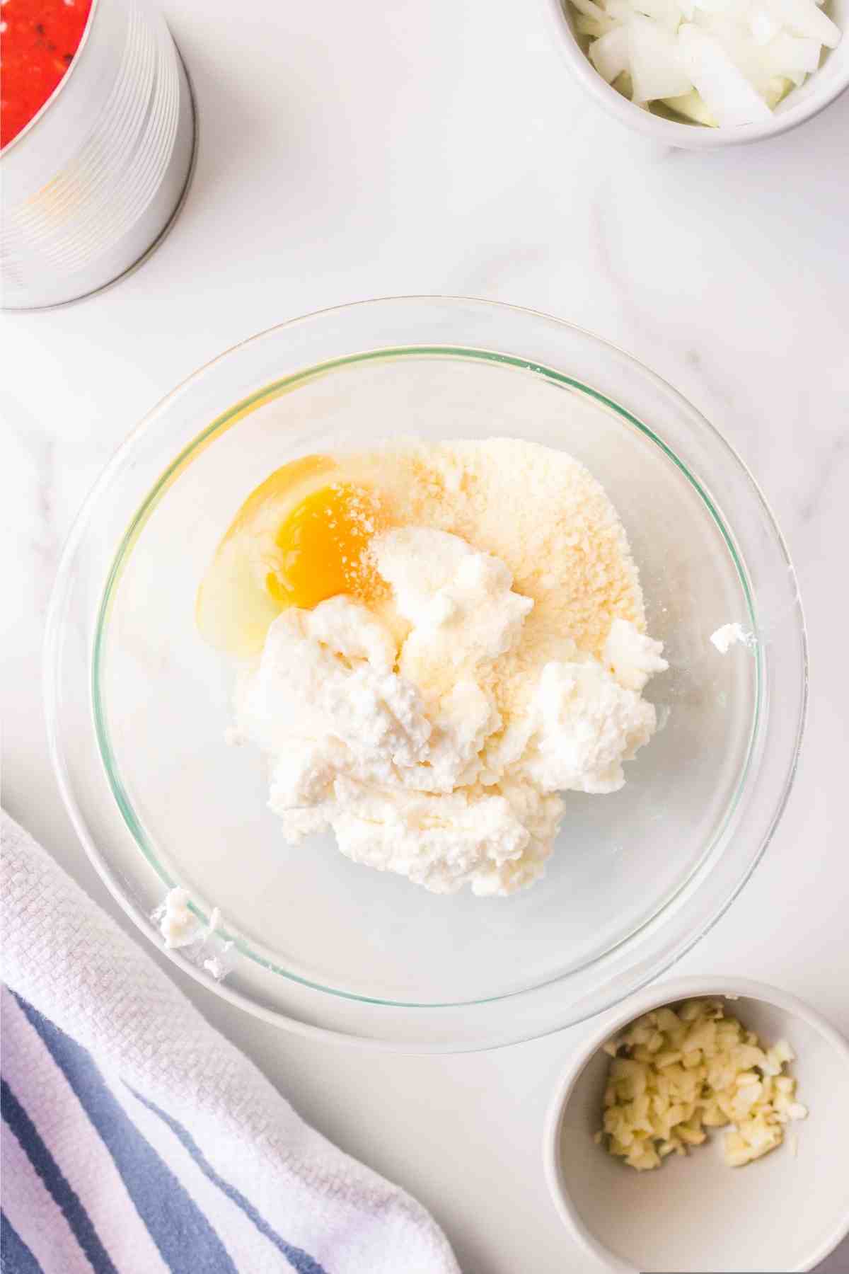 Egg parmesan and ricotta in a glass mixing bowl. 