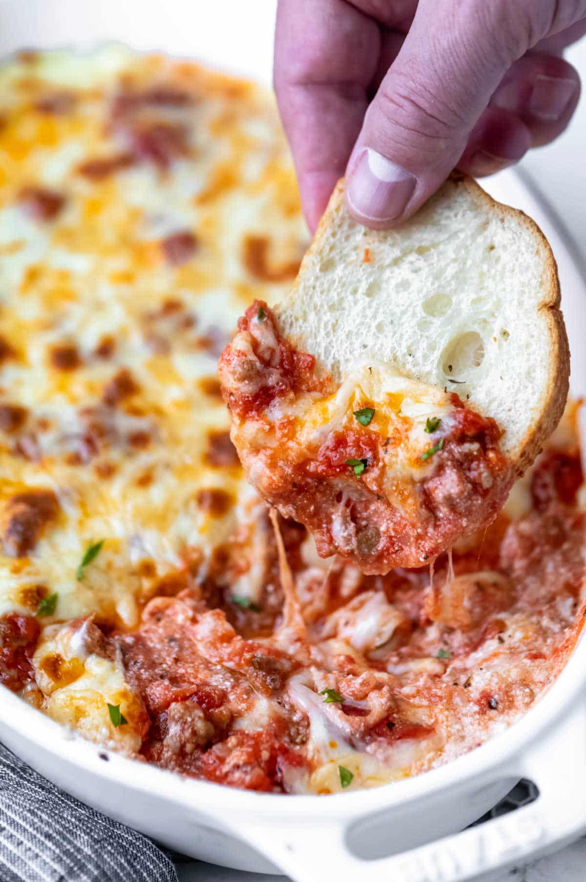 A sliced baguette in lasagna dip. 