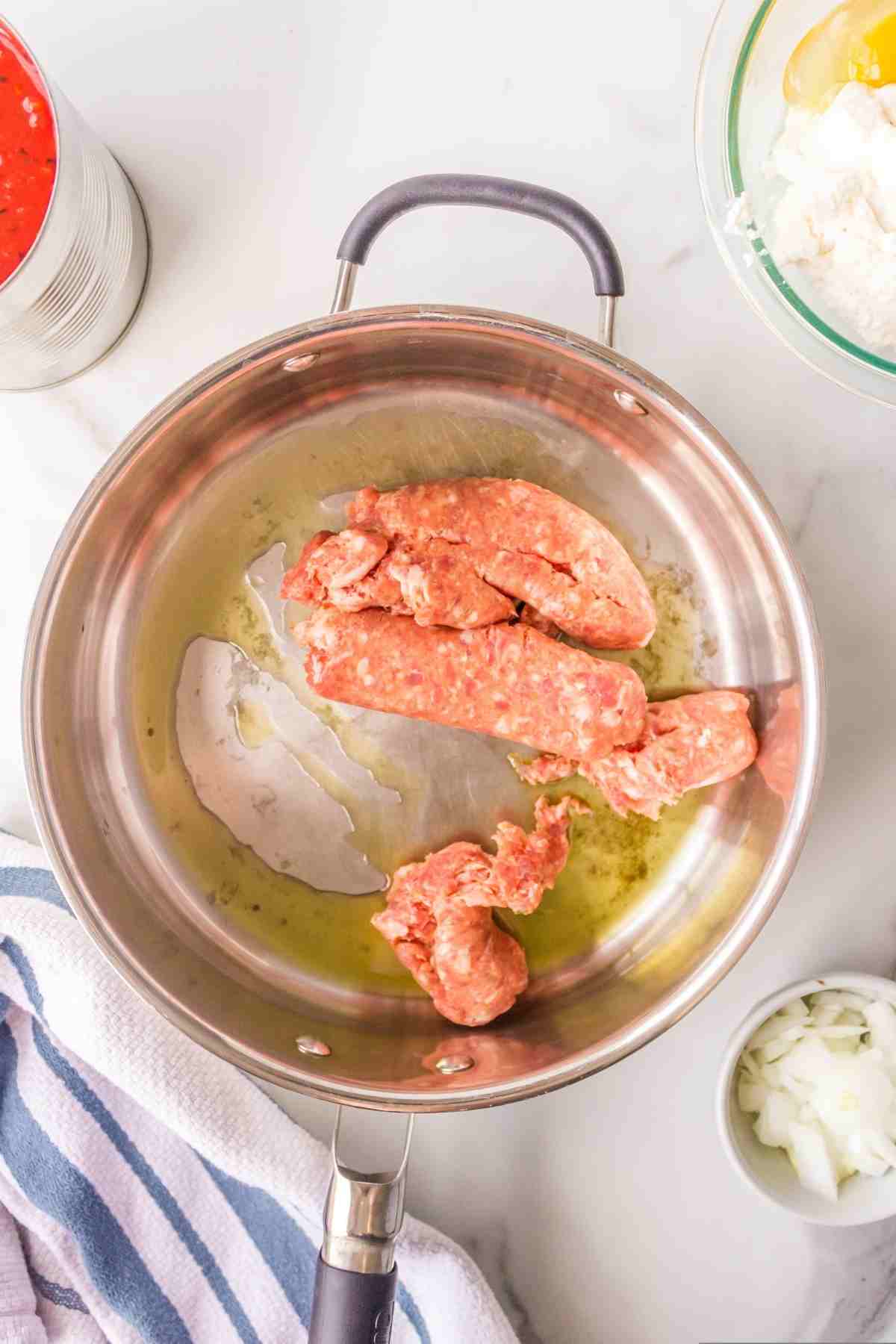 Italian sausage in a silver skillet. 