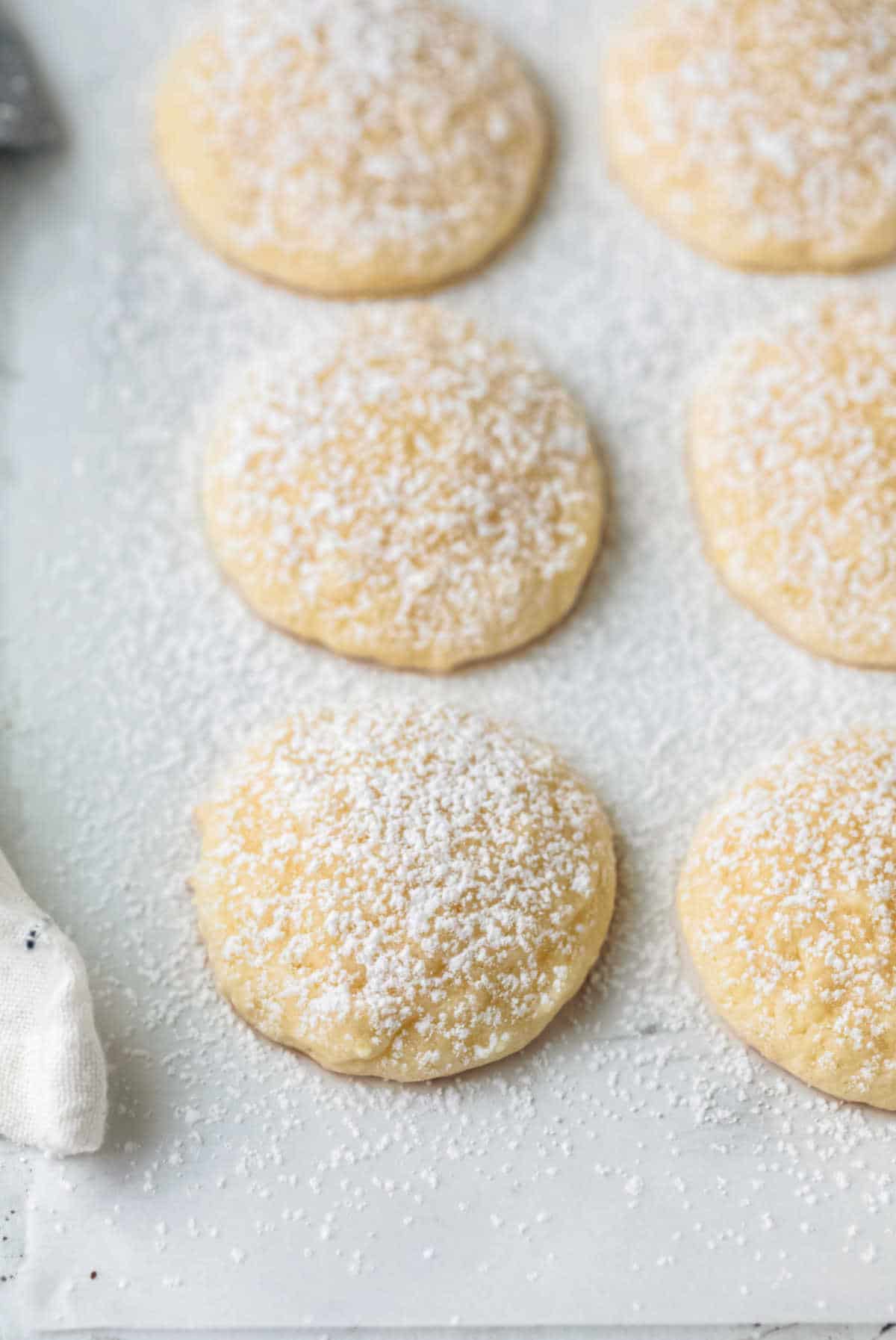 Rows of lemon cookies on a piece of parchment paper. 