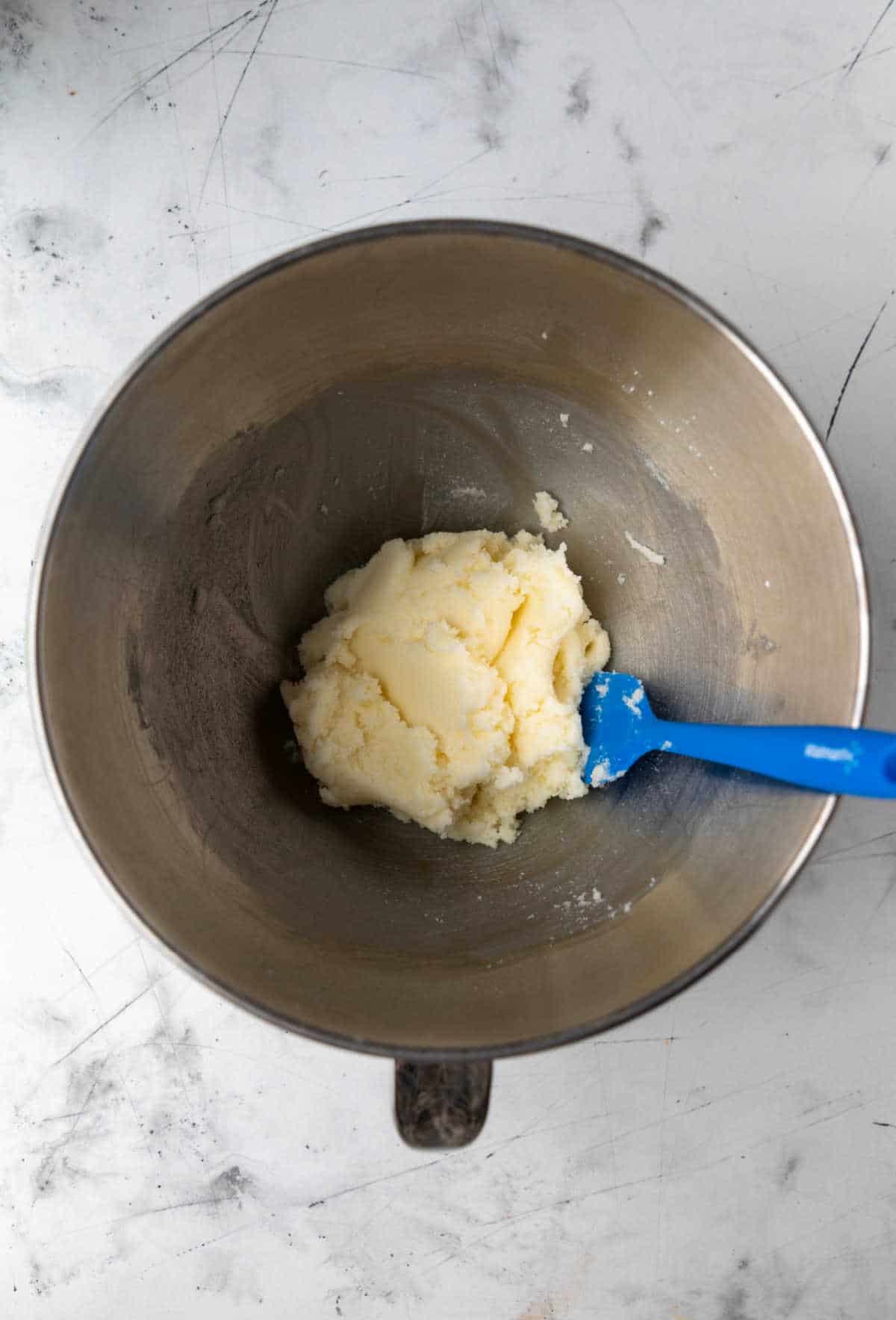 Creamed butter and sugar in a silver mixing bowl. 