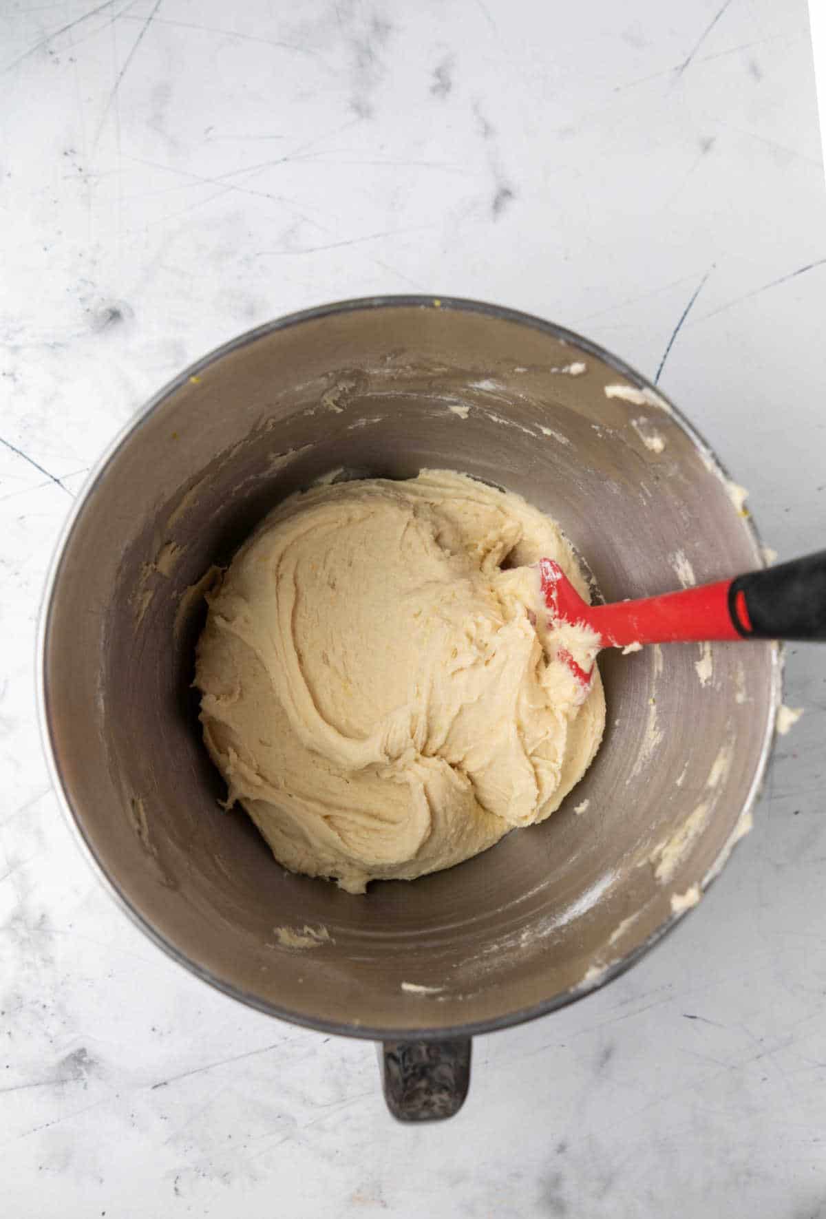 Lemon cookie dough in a silver mixing bowl. 