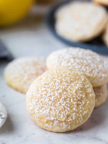 Stack of lemon cookies that have been dusted with powdered sugar.