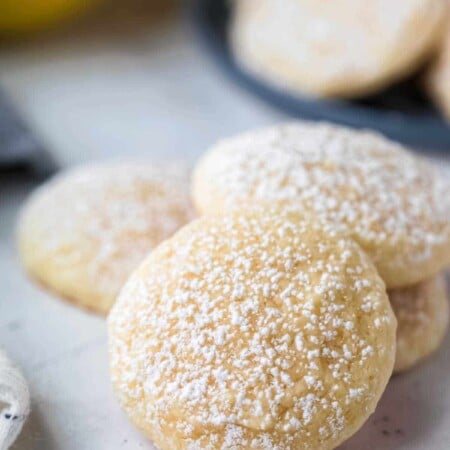Stack of lemon cookies that have been dusted with powdered sugar.