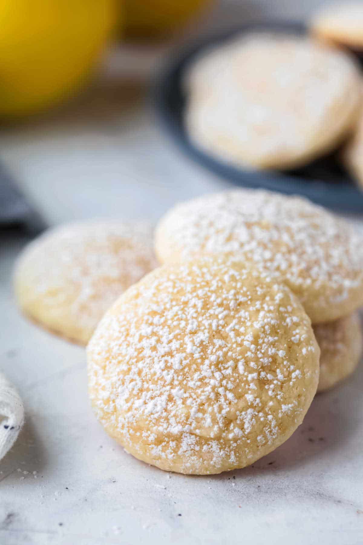 Stack of lemon cookies that have been dusted with powdered sugar. 