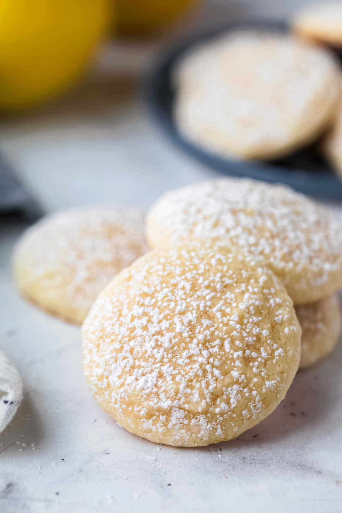 Stack of lemon cookies that have been dusted with powdered sugar.