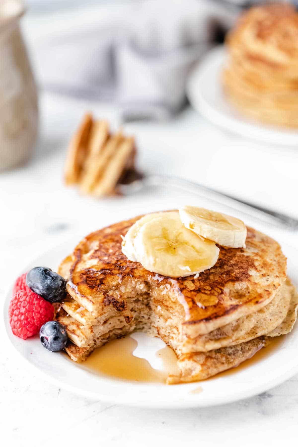A stack of whole wheat pancakes with a bite missing. 