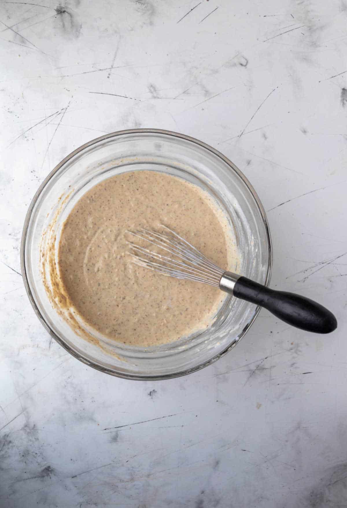 Whole wheat pancake batter in a glass mixing bowl. 