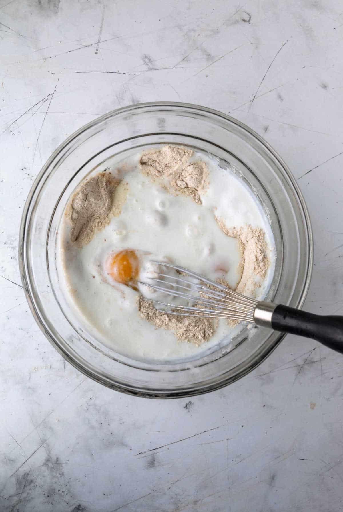 Wet ingredients on dry ingredients in a mixing bowl. 