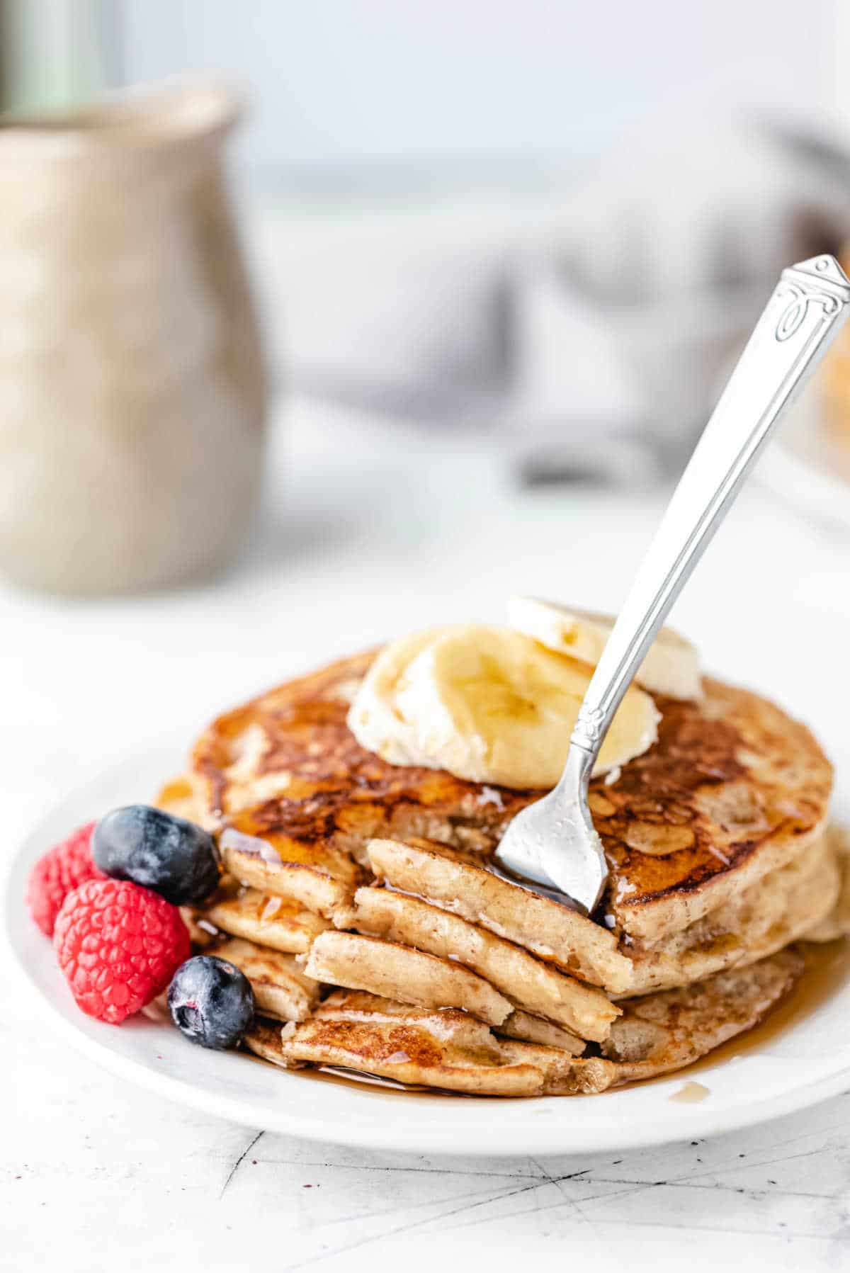 A fork taking a bite of whole wheat pancakes. 