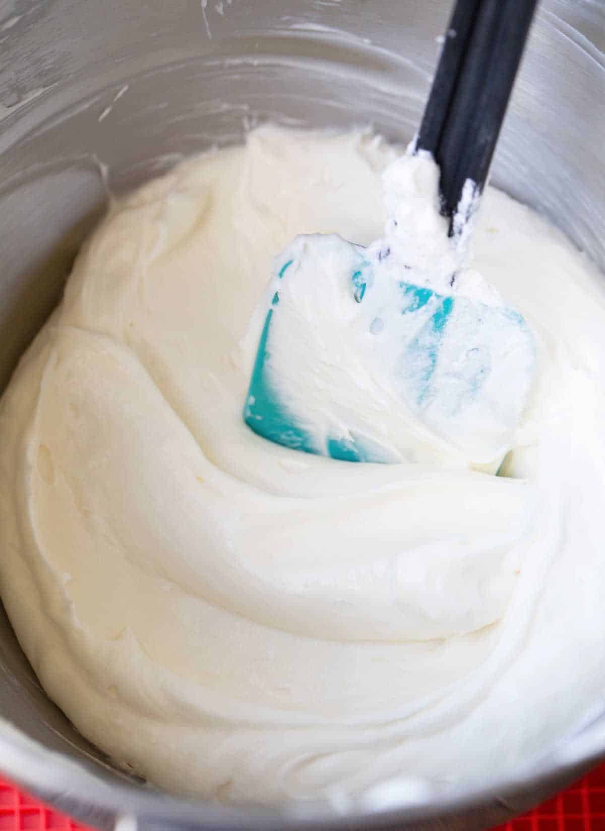 Cream cheese frosting in a silver mixing bowl. 