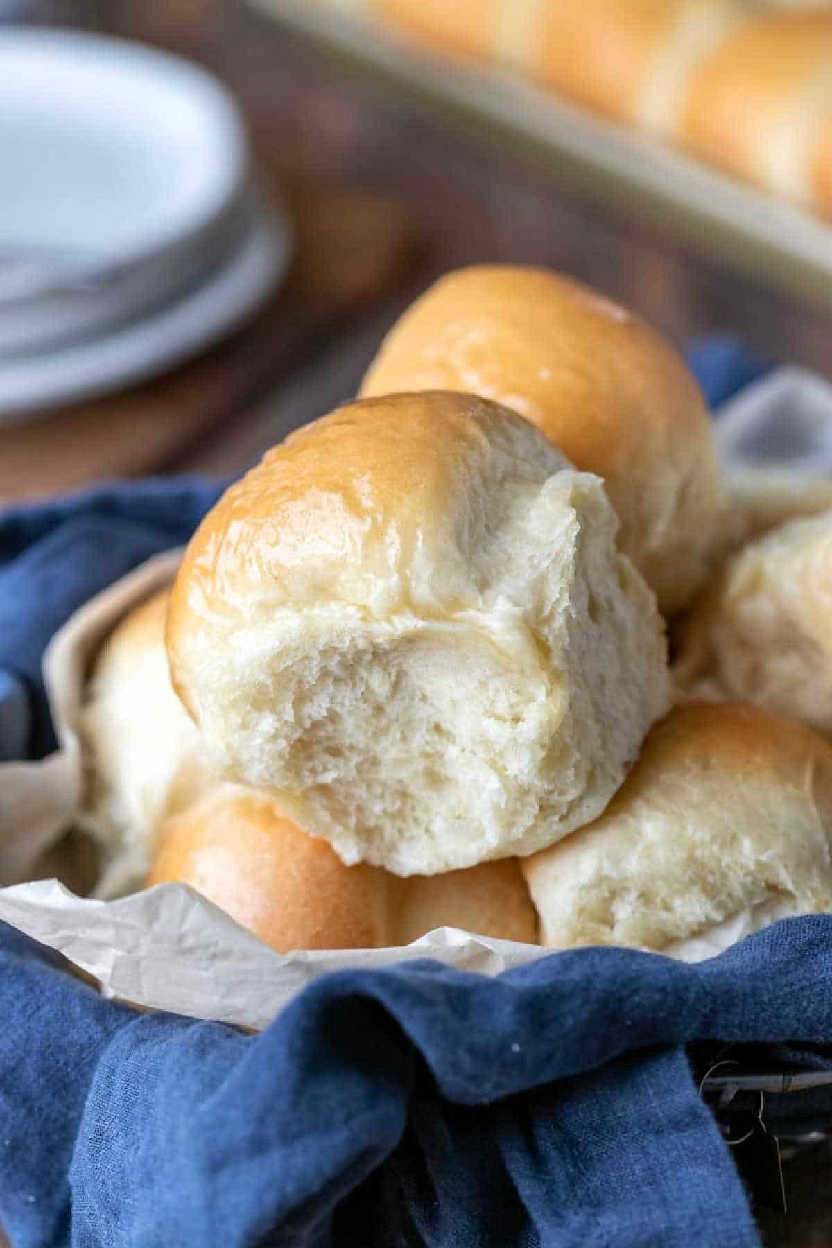 Dinner Roll Recipe Dinner rolls in a blue linen napkin lined basket.
