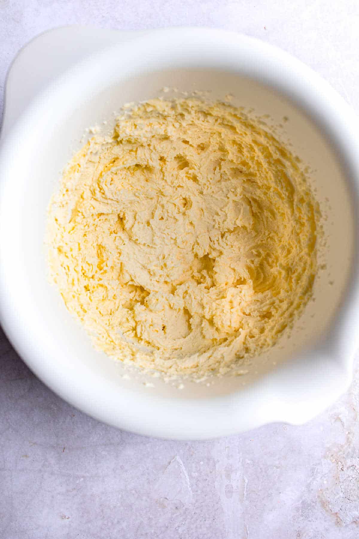 Creamed butter and sugar in a white mixing bowl. 