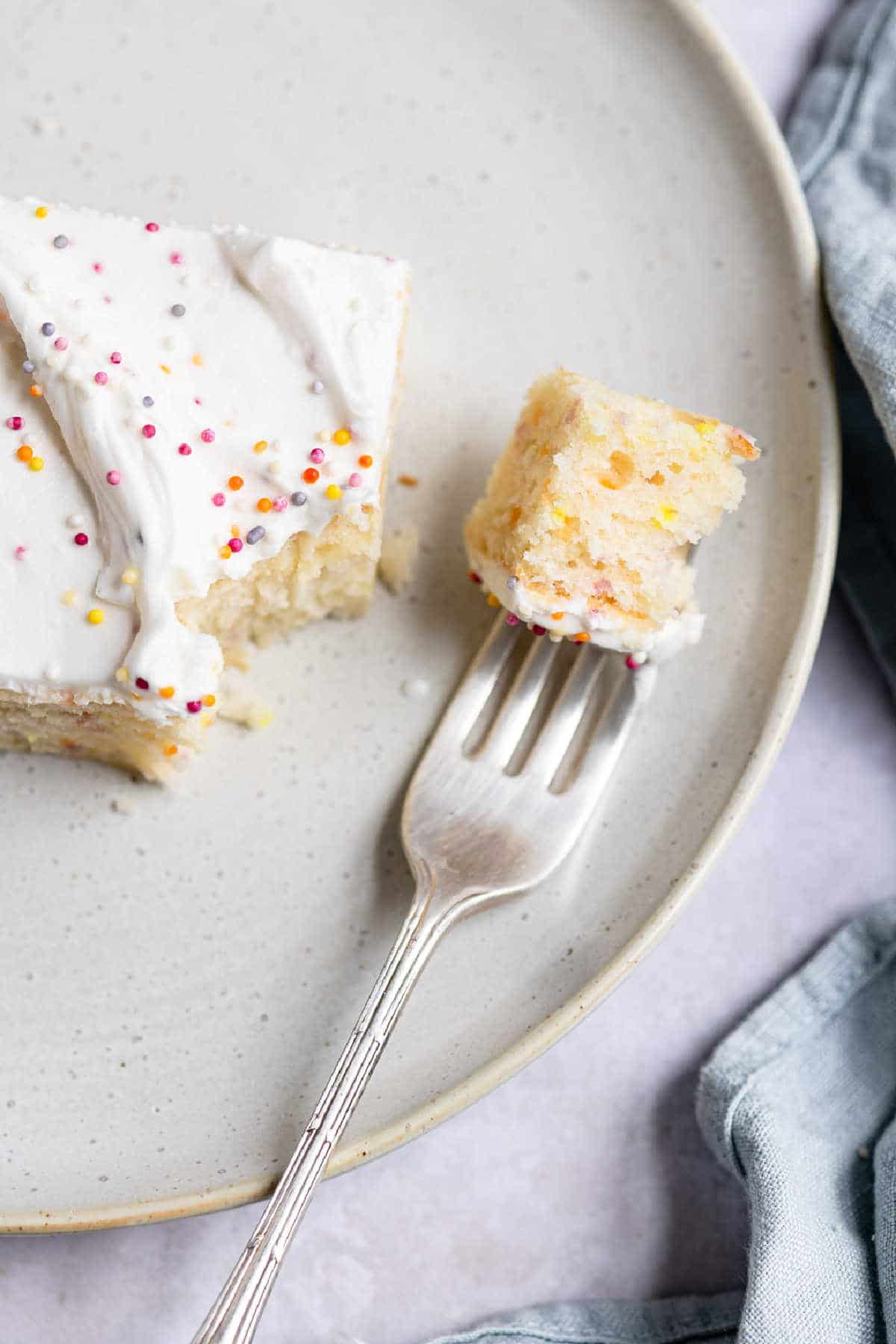 A bite of funfetti cake on a silver fork.