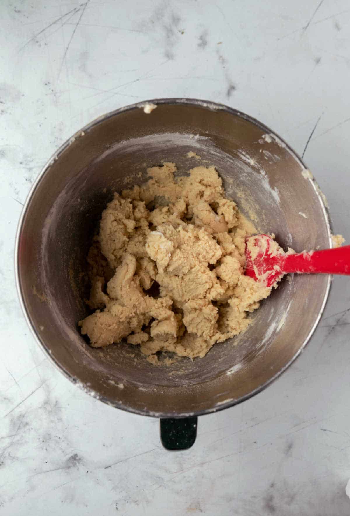 Sugar cookie dough in a silver mixing bowl. 