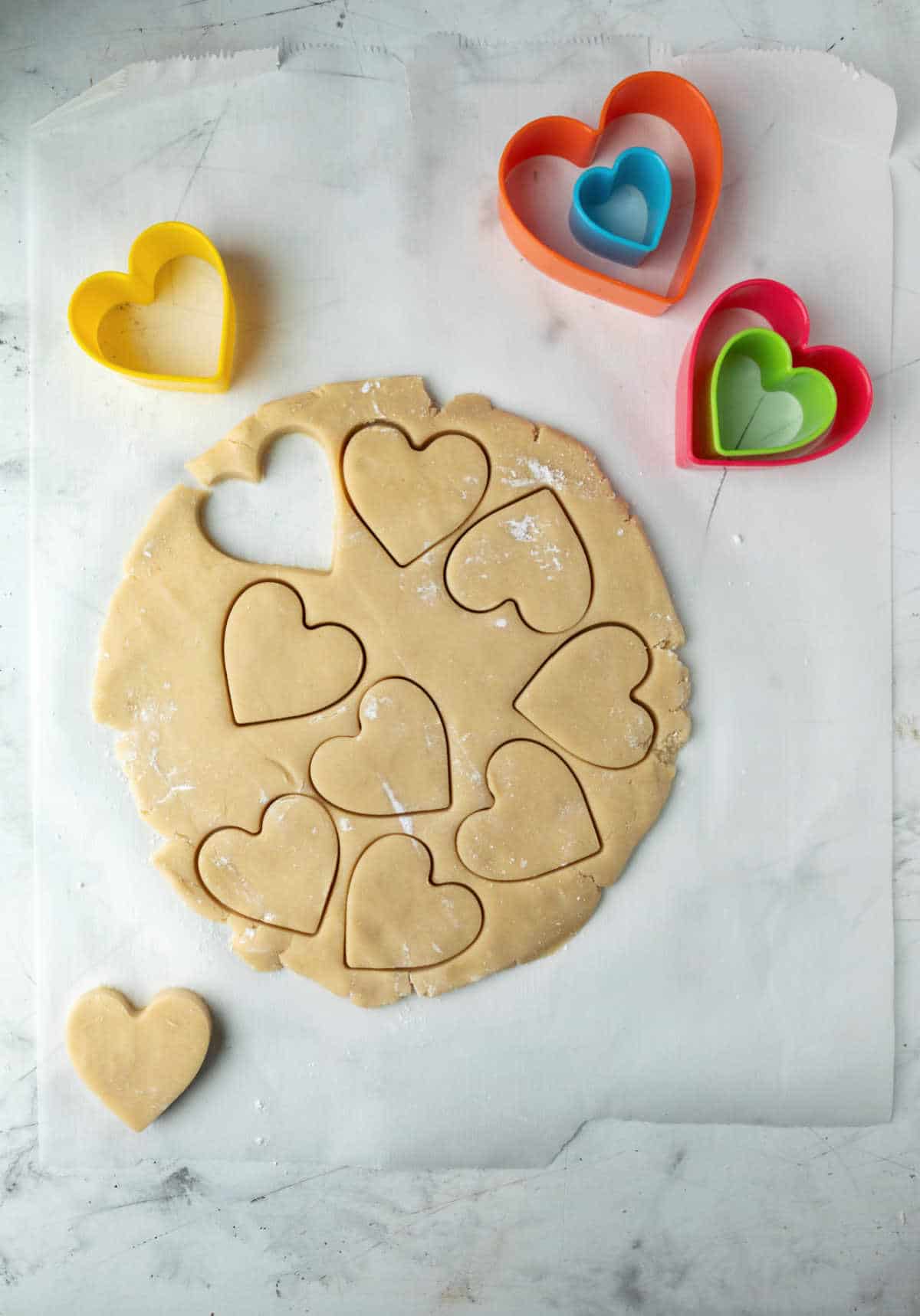 Dough with heart shaped cut outs in it.