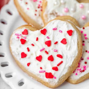 Heart shaped valentine's Day cookies on a white plate.