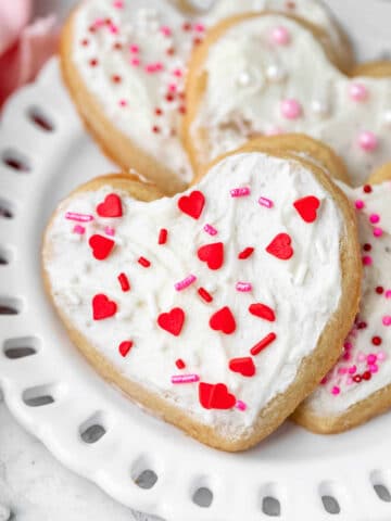Heart shaped valentine's Day cookies on a white plate.