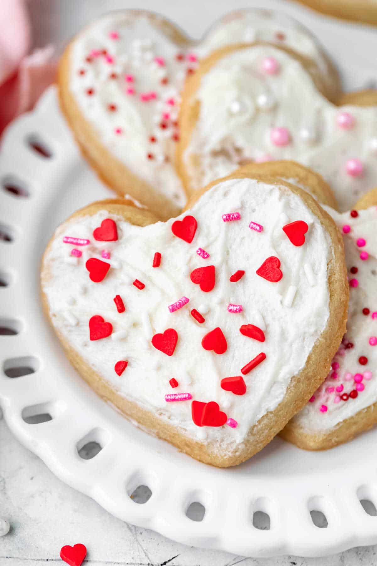 Heart shaped valentine's Day cookies on a white plate.