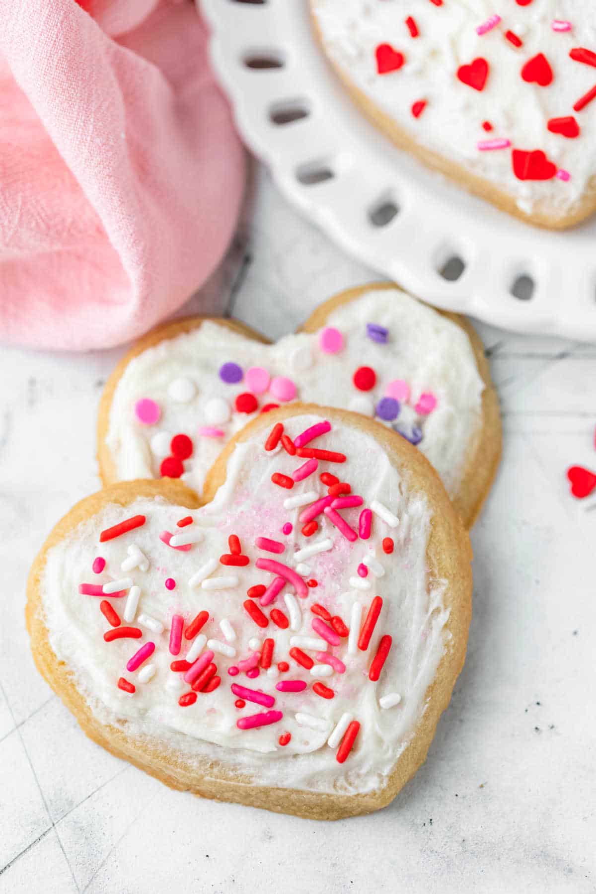Two heart shaped sugar cookies overlapping each other.