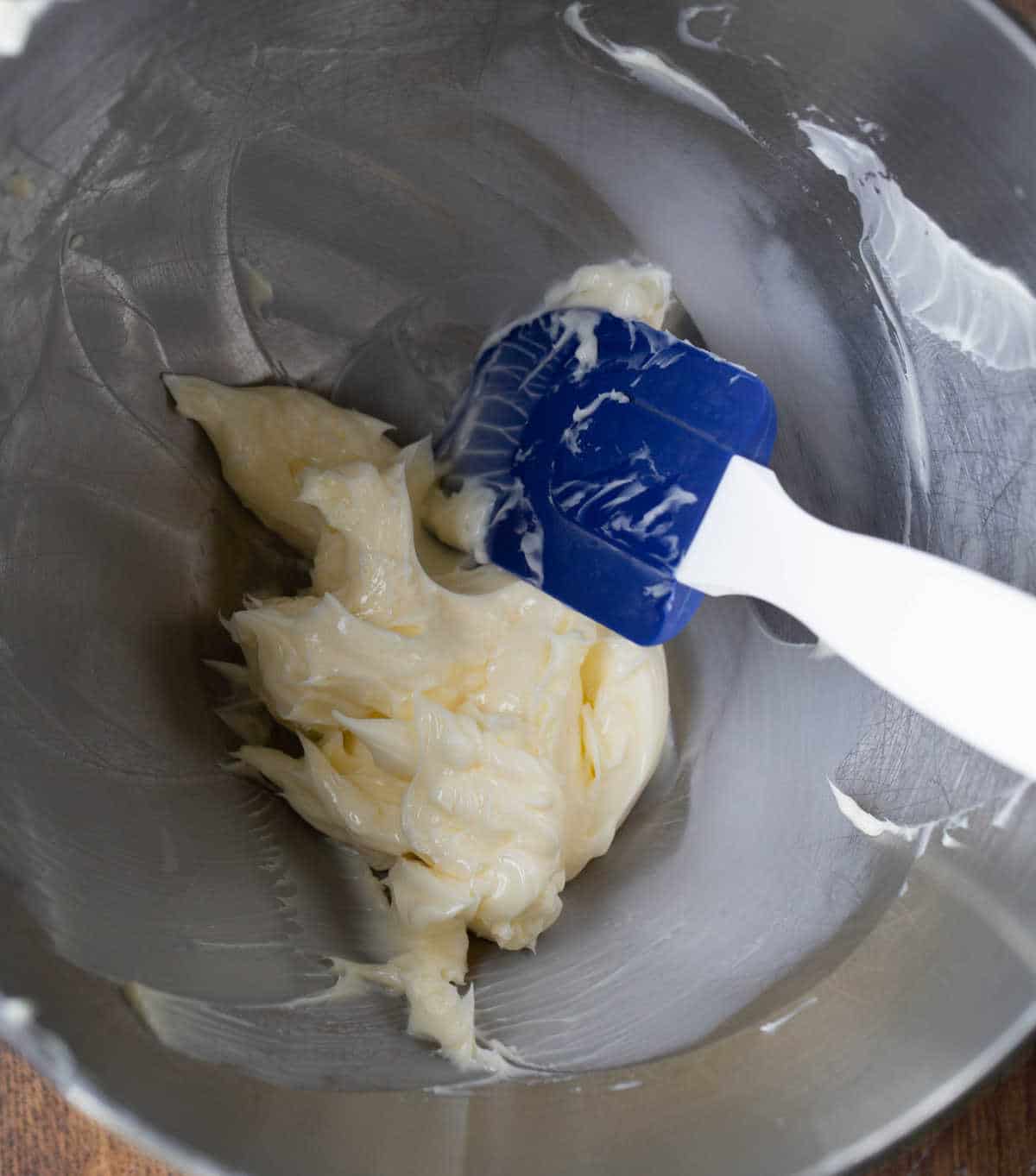 Beaten butter in a silver mixing bowl.