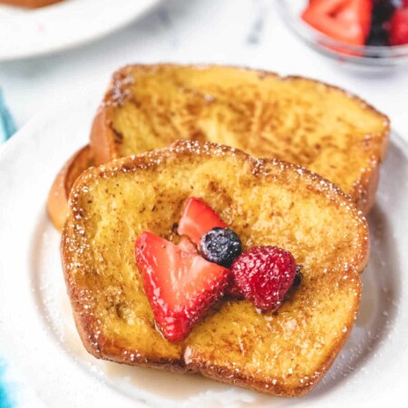 Stack of brioche French toast with berries on it.