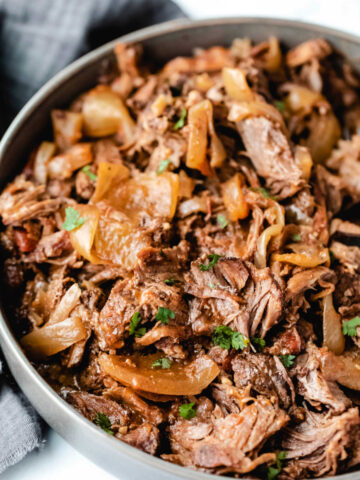 Gray bowl filled with Mexican shredded beef and onions.