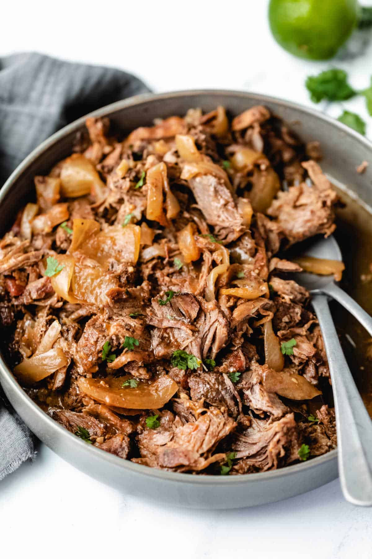 A dish of Mexican shredded beef with two fork in it. 