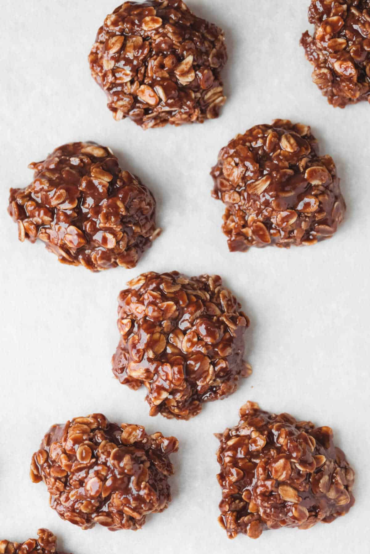 No bake cookies cooling on a piece of parchment paper. 