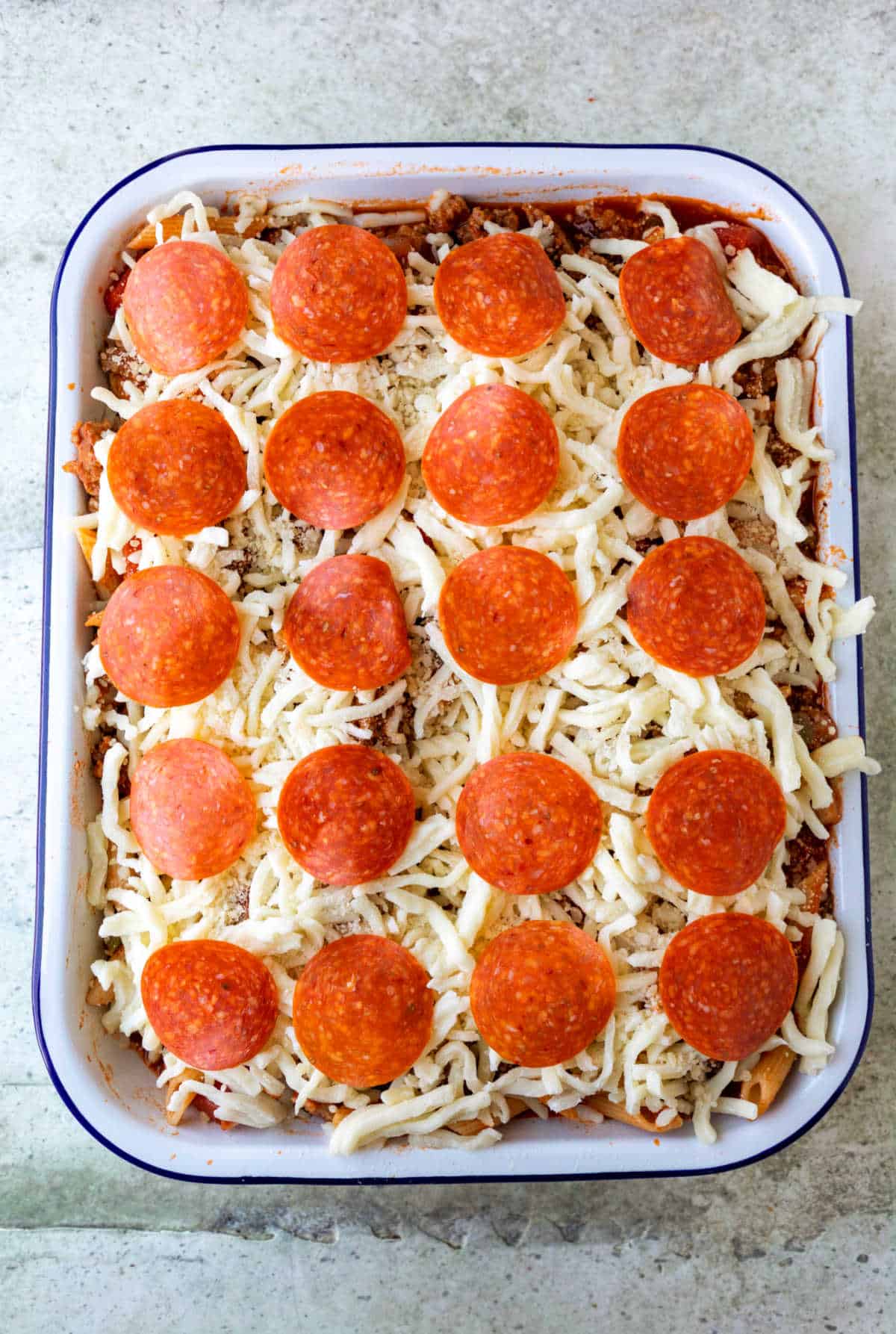 Unbaked pizza pasta in a baking pan.