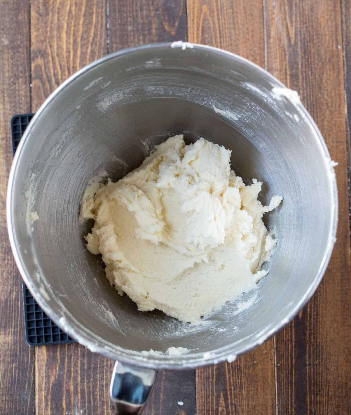 Creamed butter and sugar in a silver mixing bowl. 