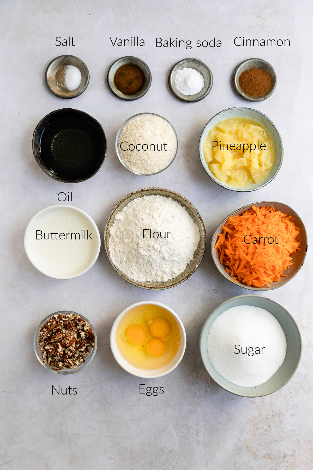 Ingredients for carrot cake with labels in dishes.