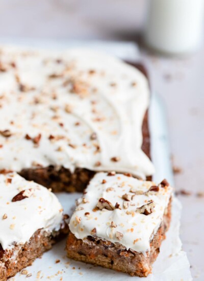 A piece of carrot cake cut from a sheet cake.