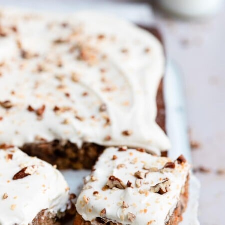 A piece of carrot cake cut from a sheet cake.