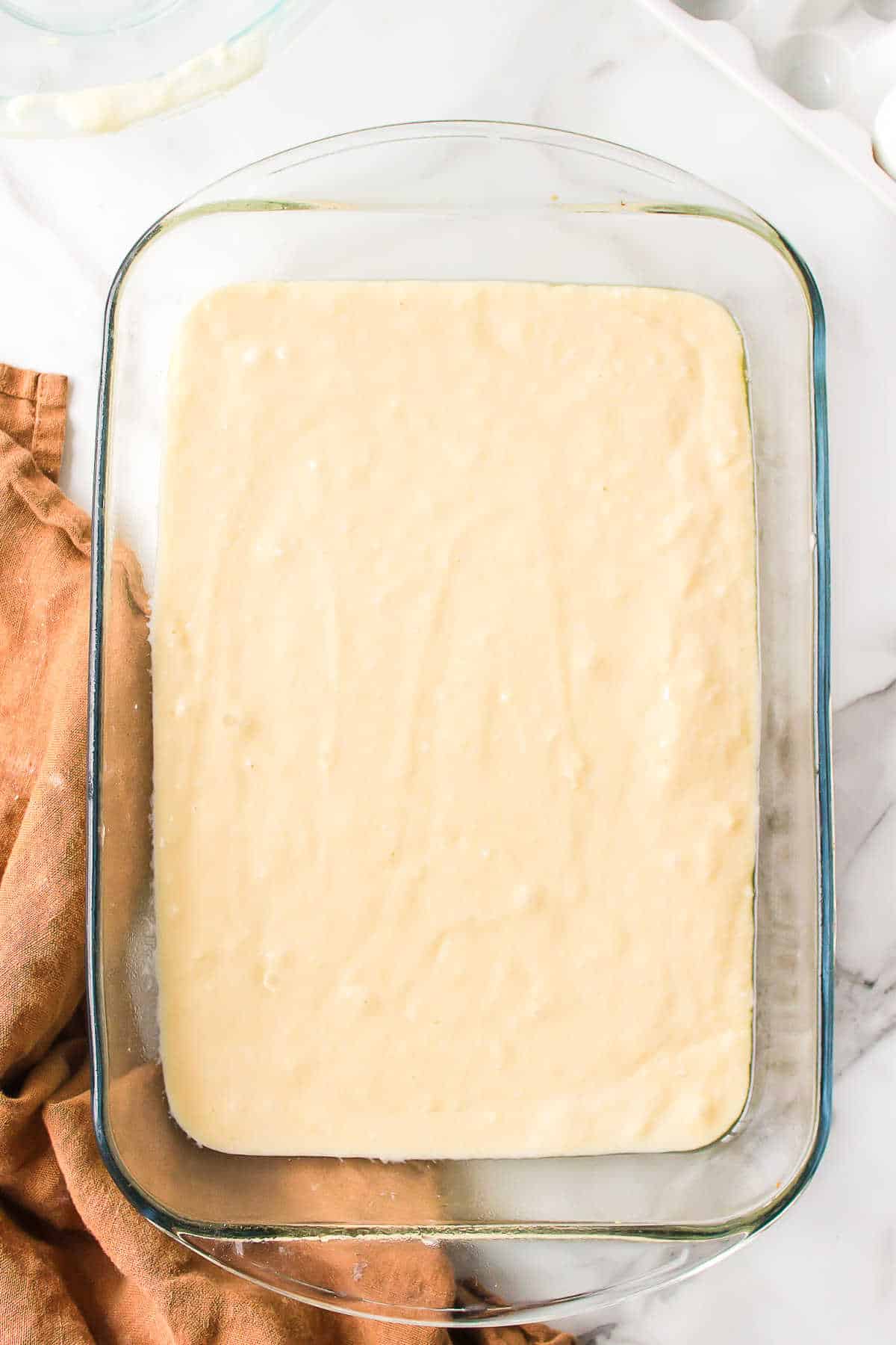 Coconut cake batter in a glass pan. 
