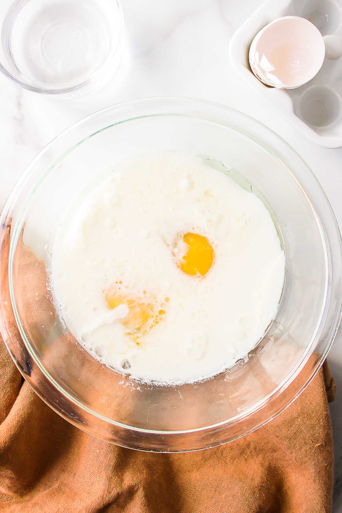 Wet ingredients for coconut poke cake in a mixing bowl. 