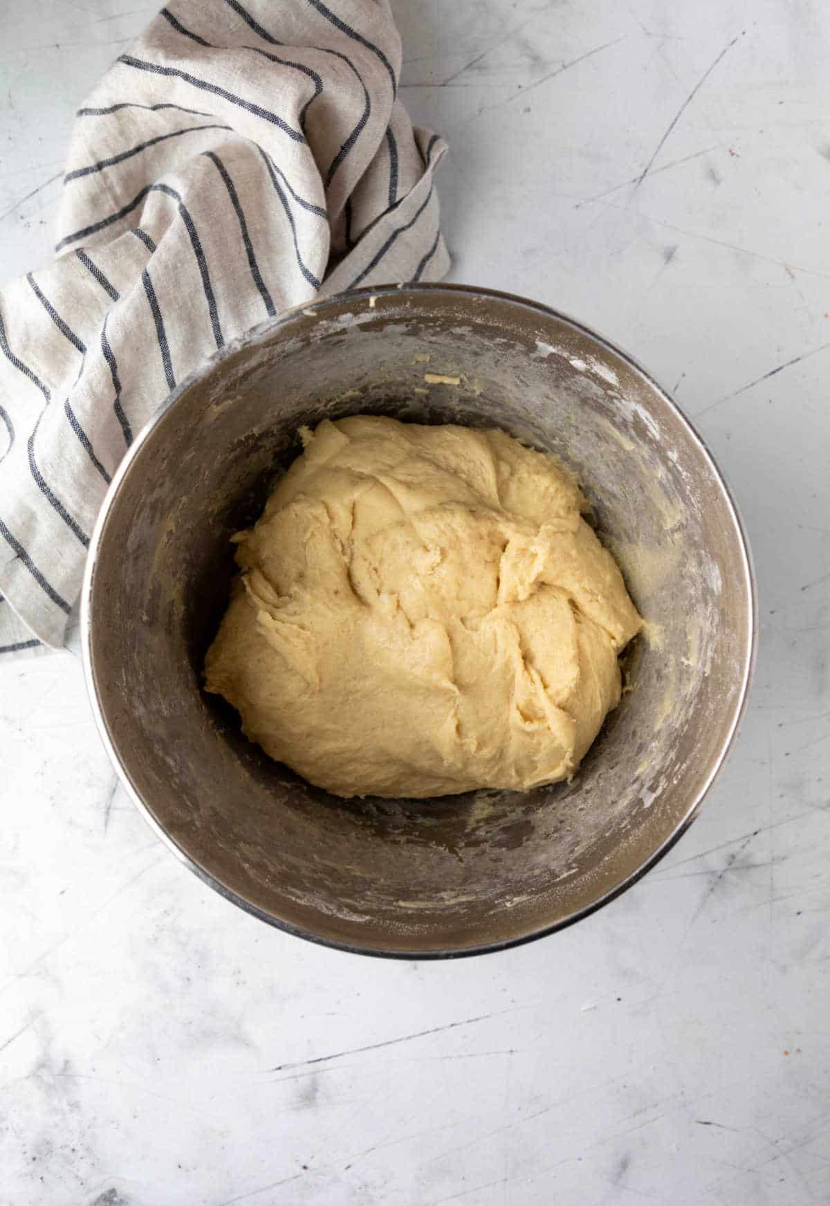 Hawaiian roll dough in a silver mixing bowl. 