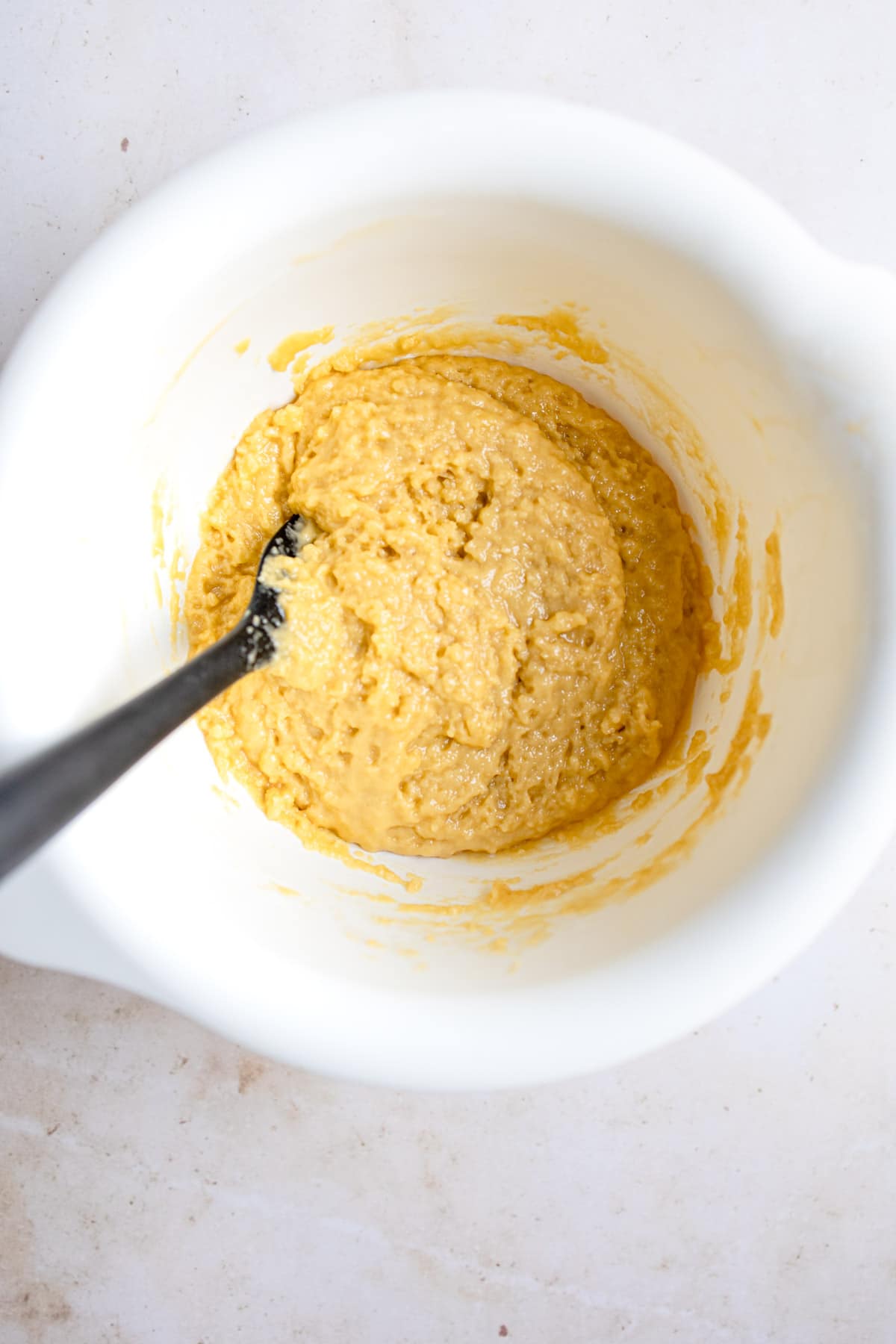 Sugar oil and other ingredients for sponge cake in a white mixing bowl. 