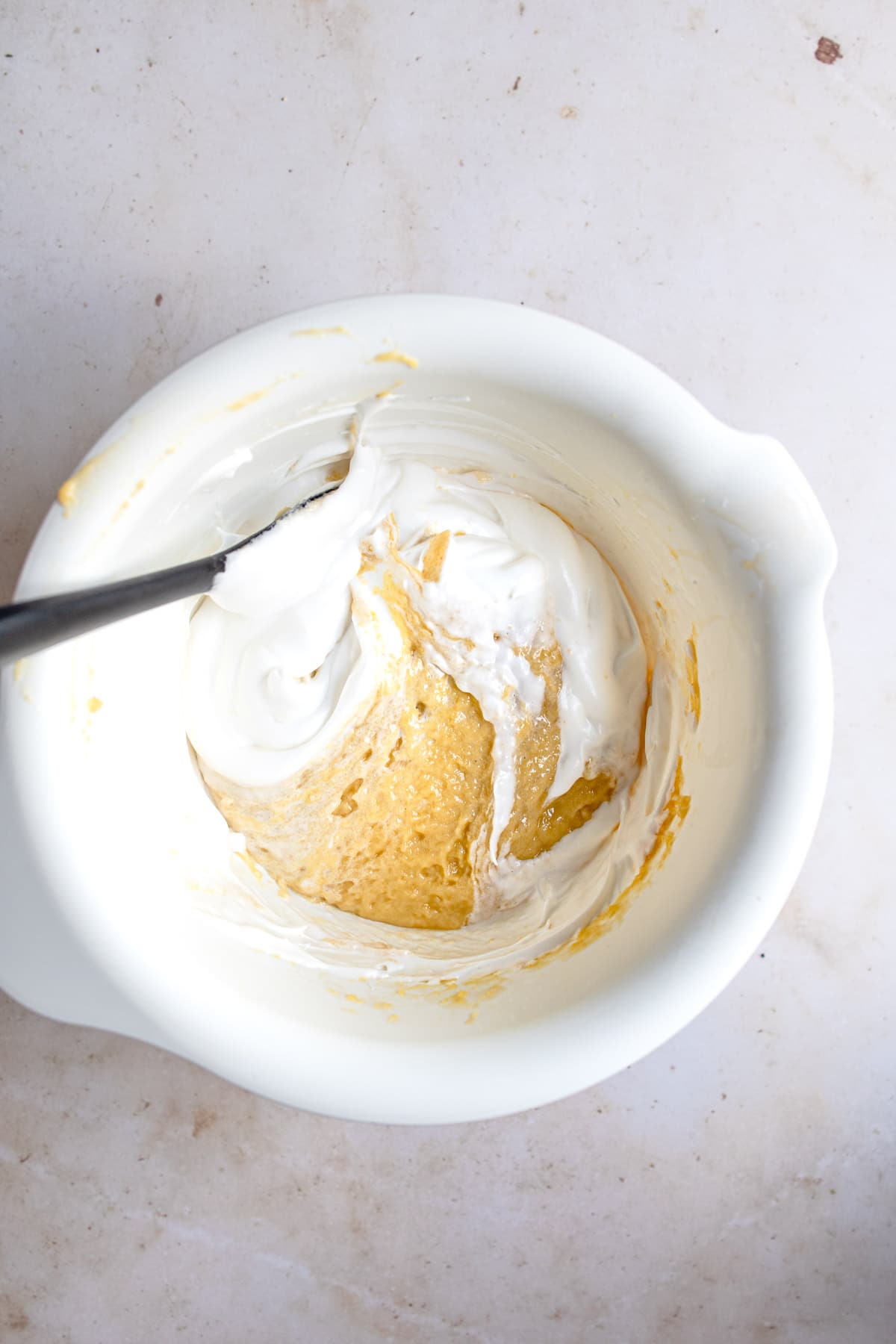 Folding egg whites into cake batter.