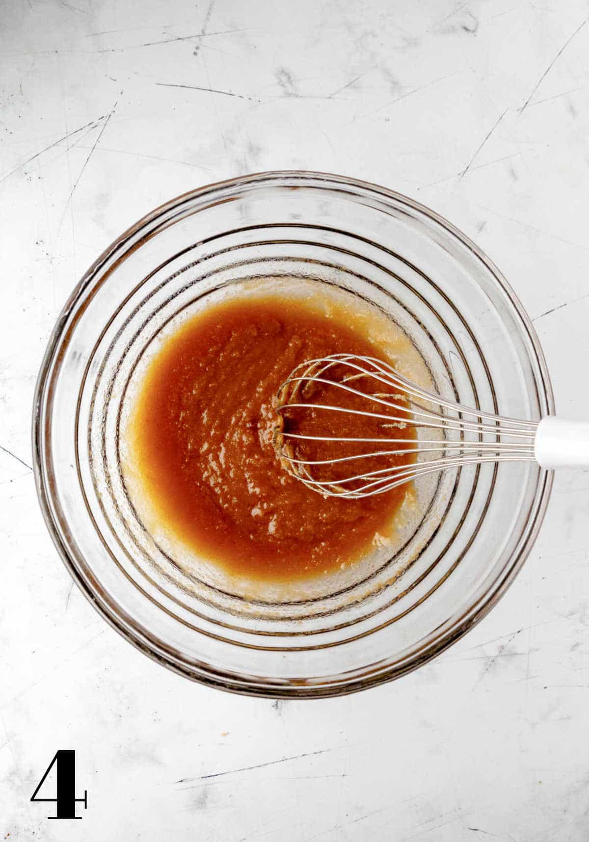 Sugar egg and vanilla whisked into melted butter in a mixing bowl.