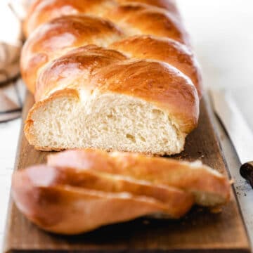 A loaf of braided bread with three slices cut off.