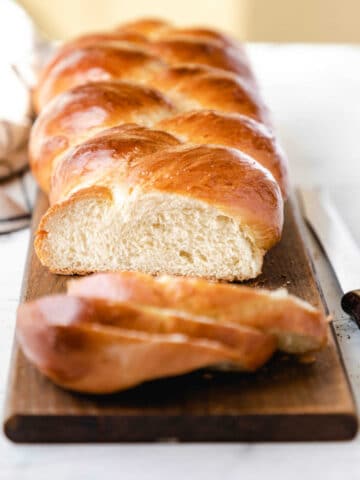 A loaf of braided bread with three slices cut off.