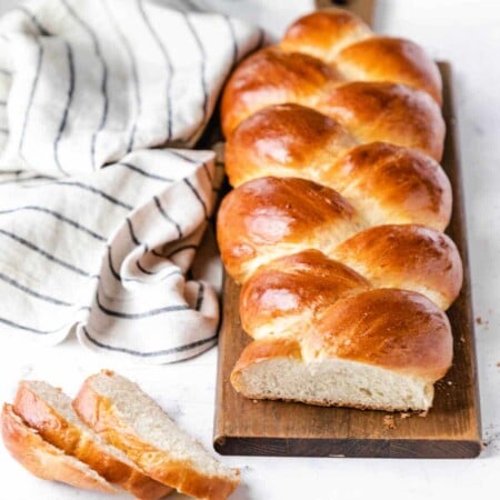 A loaf of braided bread on a cutting board.