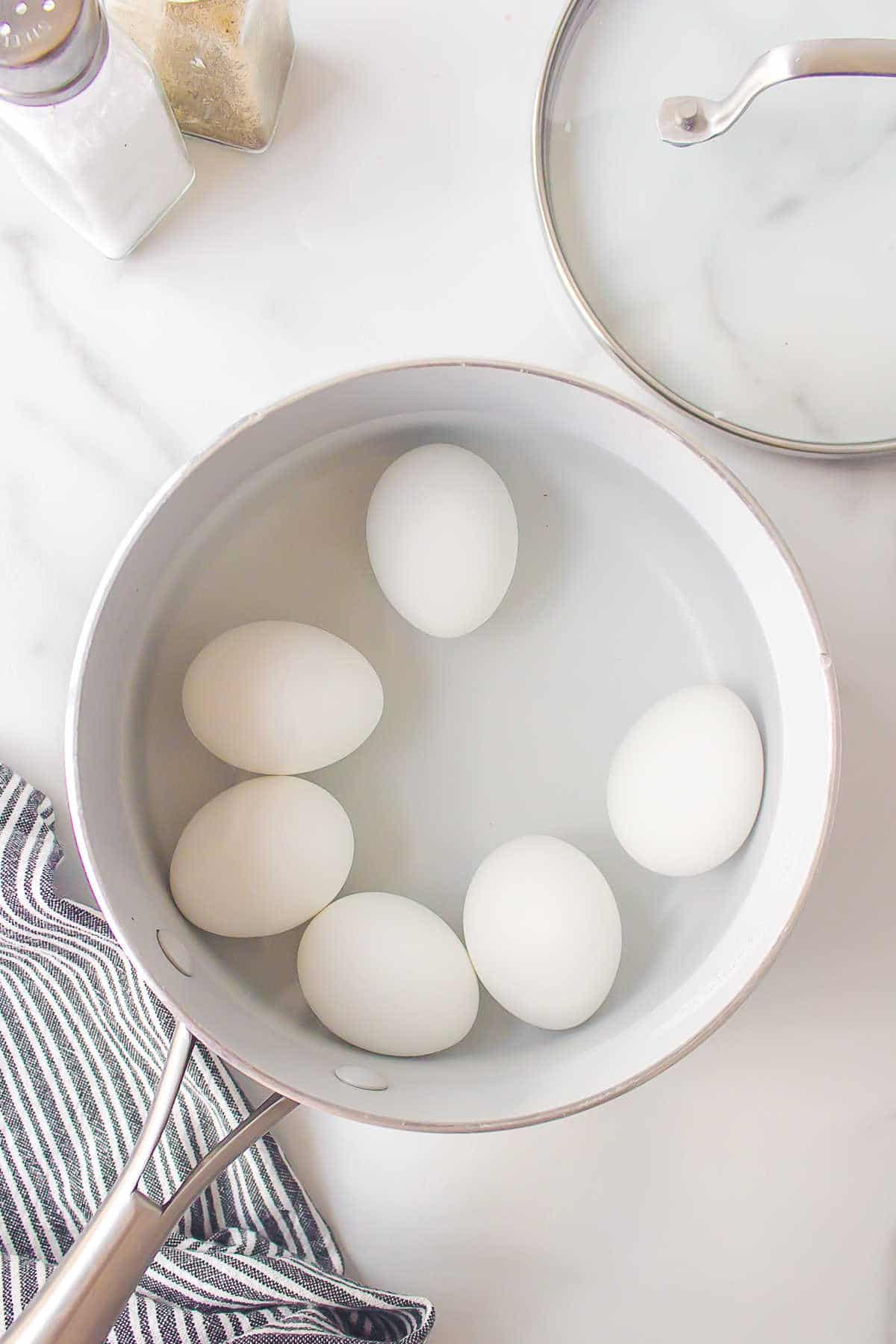 Boiled eggs in a pot of water.