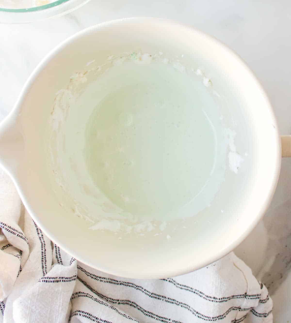 Marshmallow creme and creme de menthe mixed together in a bowl.