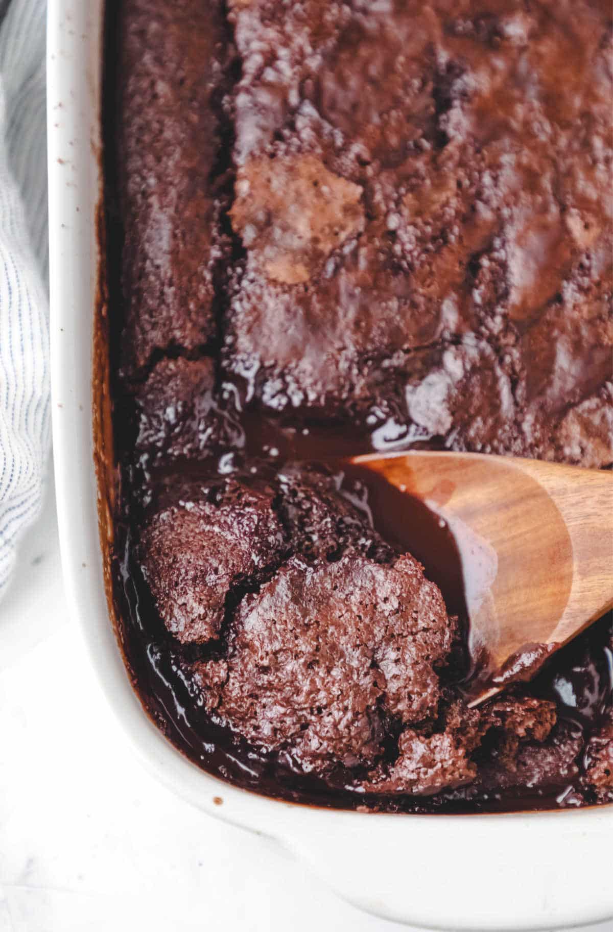 A wooden spoon in a hot fudge chocolate pudding cake. 