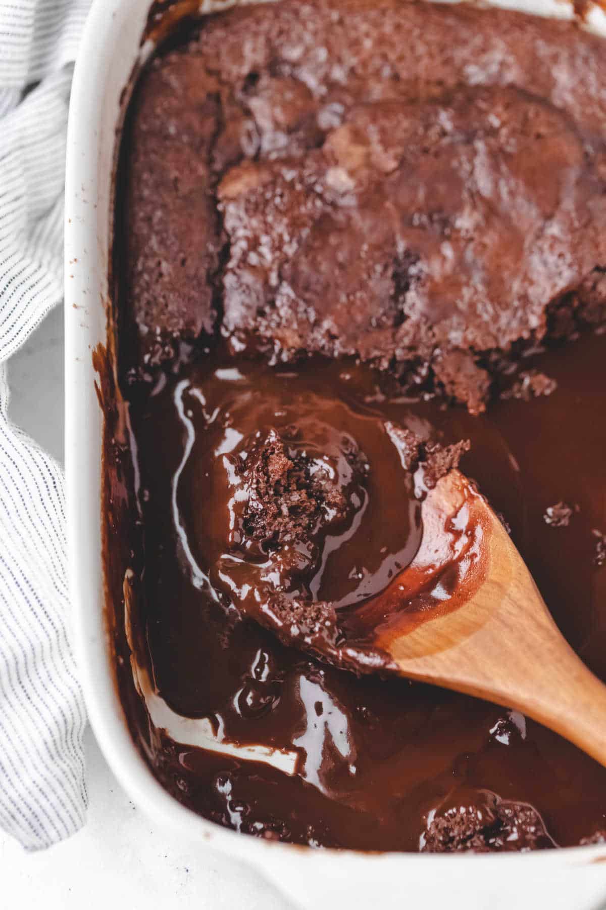 A wooden spoon with a scoop of hot fudge cake on it. 