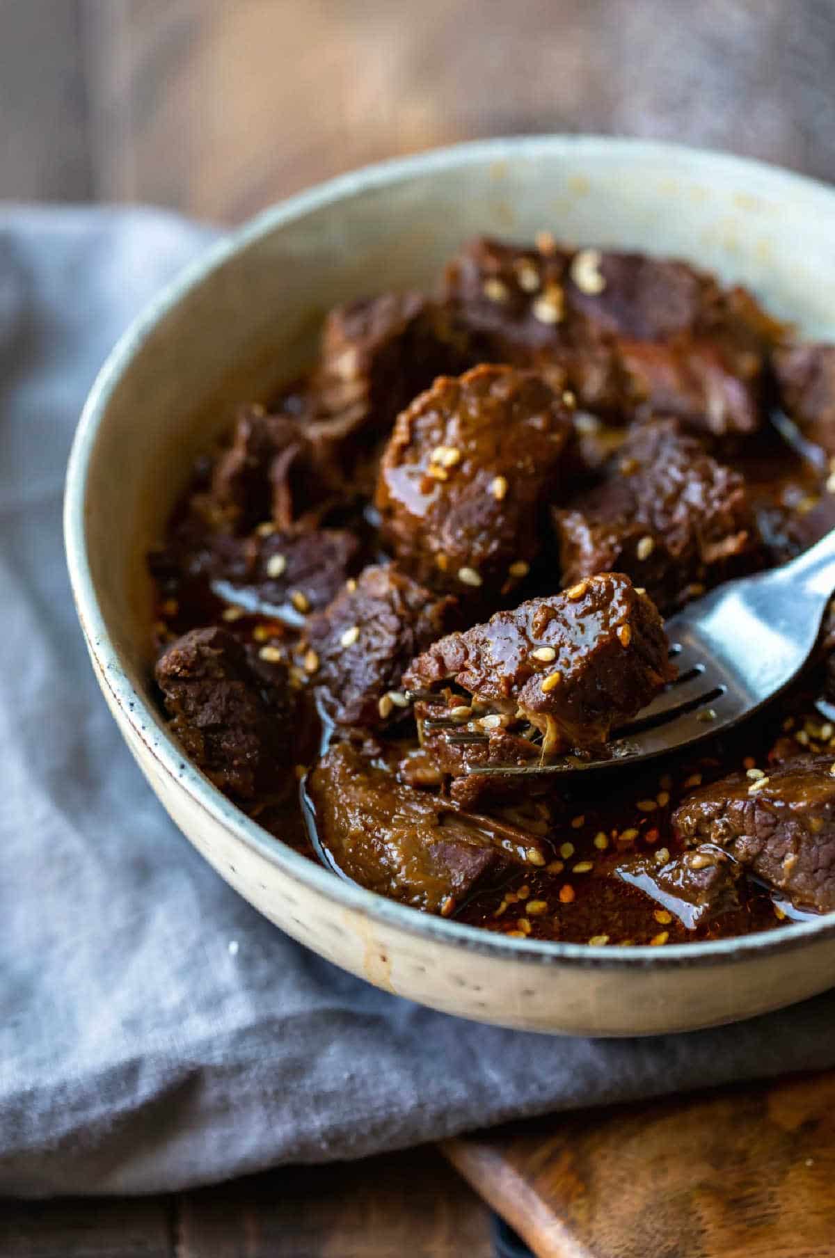 Instant Pot Korean Beef A fork holding a piece of Instant Pot Korean beef.