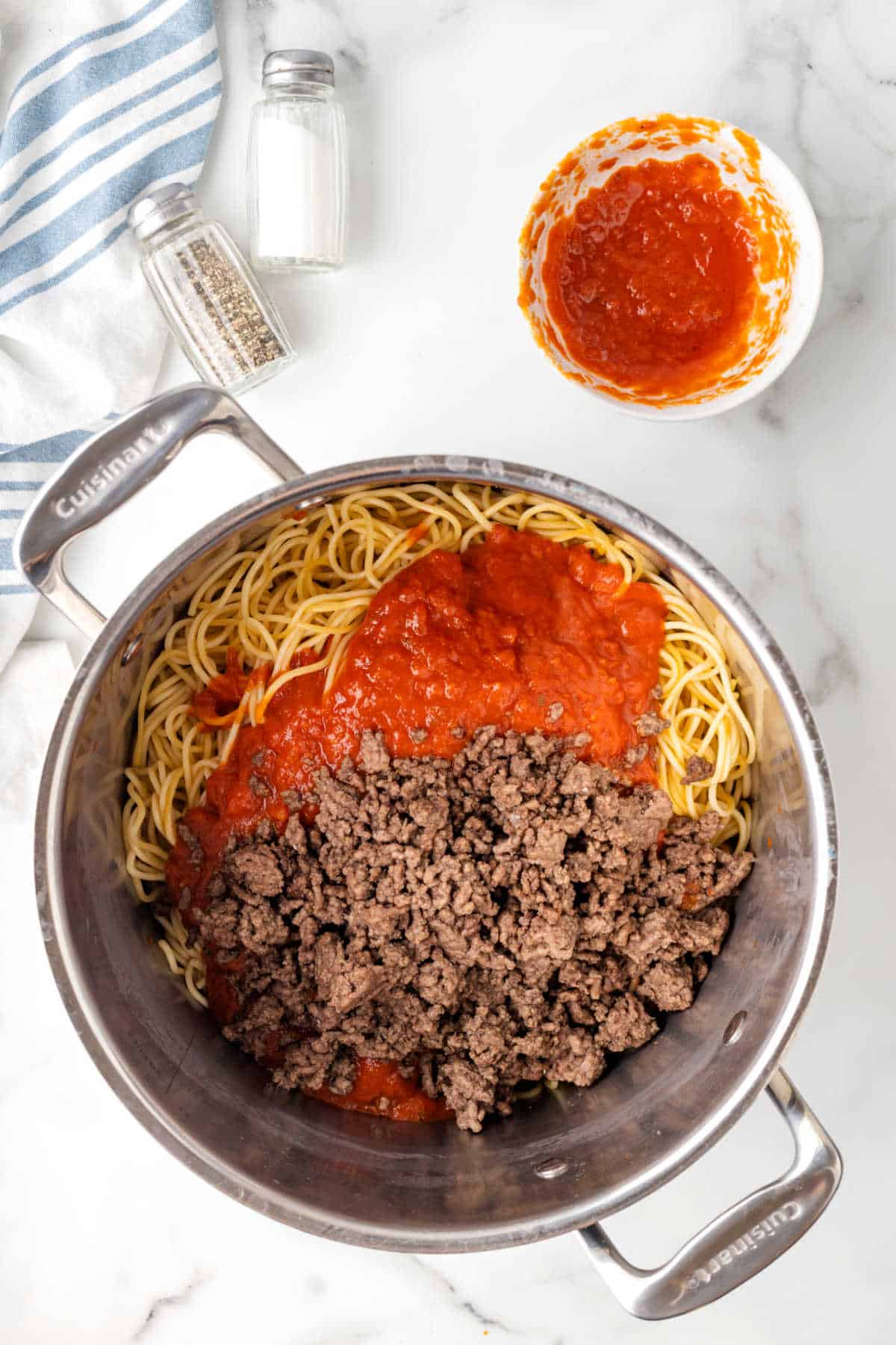 A pot with spaghetti noodles, pasta sauce, and ground beef. 