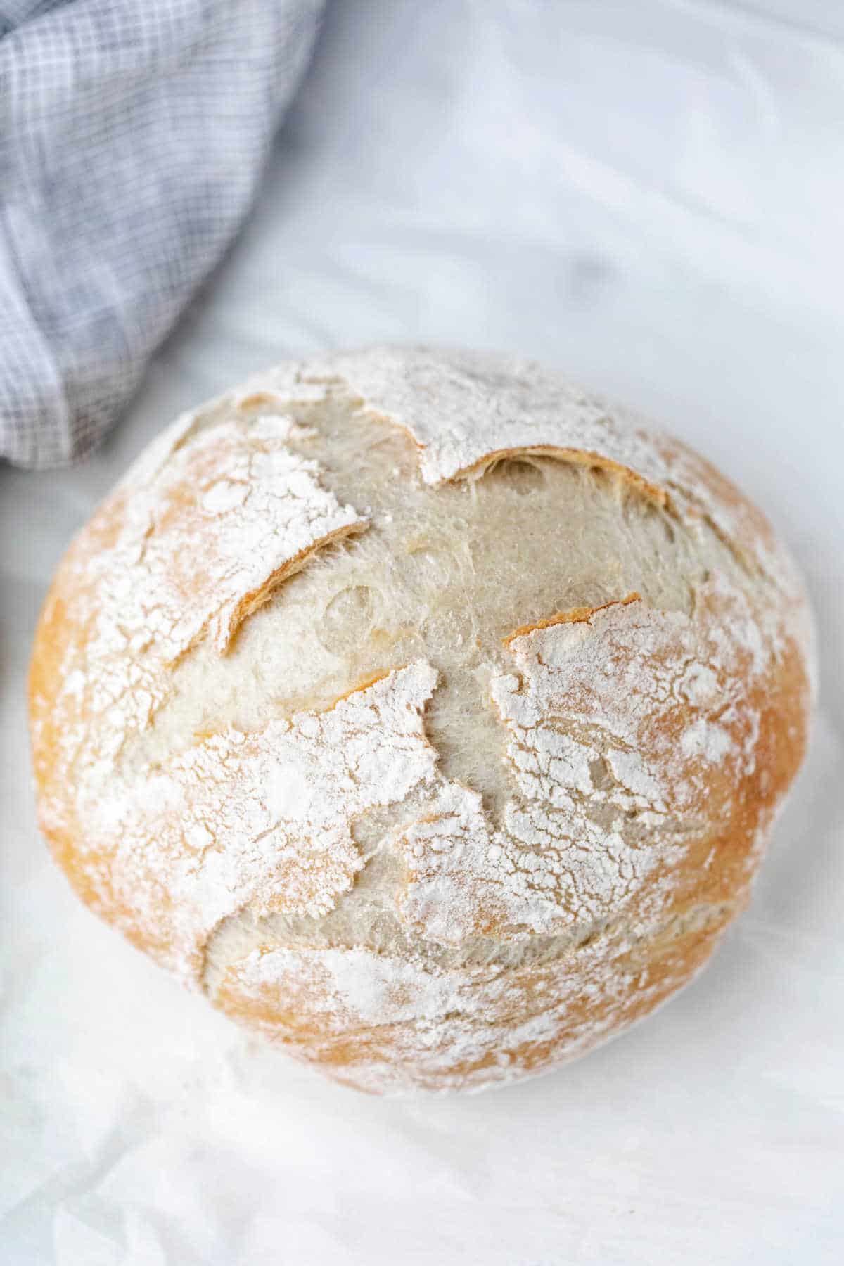 A loaf of no knead bread on a marble background. 